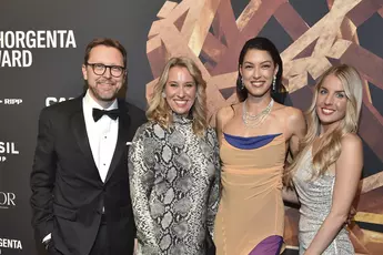 Four people in evening dress pose in front of a logo wall with the INHORGENTA AWARD trophy.