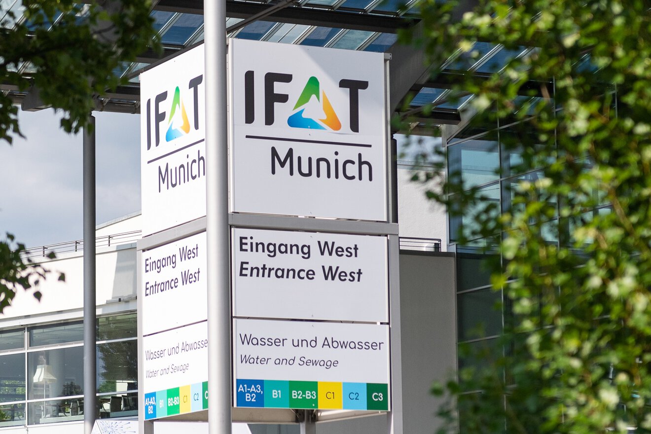 In the photo, you can see a column next to a large entrance with the words ‘IFAF Munich’ written in colour