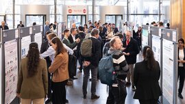 Attendees viewing and discussing scientific posters during the LOPEC poster session