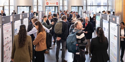 Attendees viewing and discussing scientific posters during the LOPEC poster session