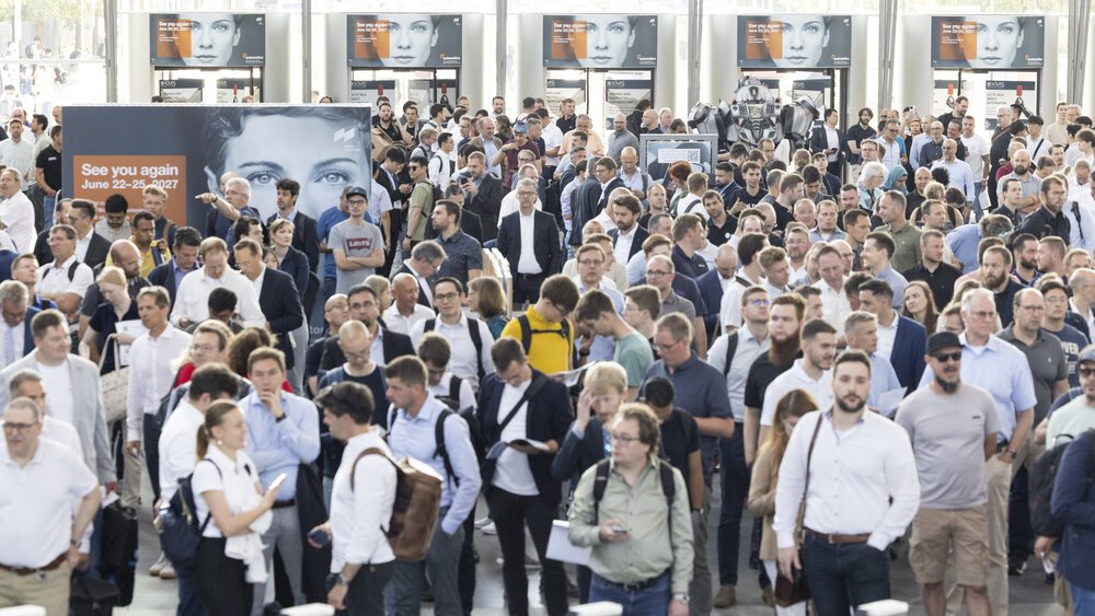 Zahlreiche Besucher stehen und warten vor den Ticketkontrollen auf den Einlass zur automatica Messe auf dem Messe München Gelände.