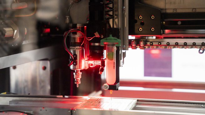 Nahaufnahme einer Maschine mit Präzisionsinstrumenten und roter LED-Beleuchtung.