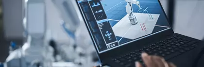 Hand of person using laptop to program robotic arm using advanced technology such as AI