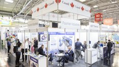 Auf dem Bild ist ein großer Gemeinschaftsstand von Kanada zu sehen. Der Stand befindet sich in Halle B2 der Messe München auf der IFAT Munich. Man erkennt Firmennamen wie „Fournier Industries und AEP Thermal. Im Hintergrund finden angeregt Unterhaltungen zwischen den Ausstellern und interessierten Besuchern statt.
