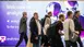A group of people walk past a large sign in shades of purple that reads 'Welcome to analytica 2014'.