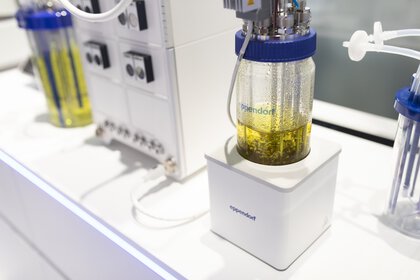 Laboratory setup with a glass container filled with yellow liquid and connected to a device.