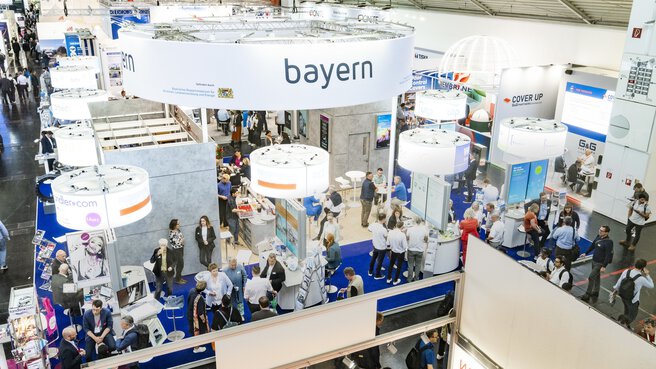 Visitors at the world’s leading trade fair on waste disposal, water and recycling management IFAT Munich. The picture shows the joint stand of Bayern innovativ. You can see the individual stands participating in the joint stand. Lively discussions are taking place at the individual stands and the exhibitors are presenting the latest technologies they have brought to the trade fair.
