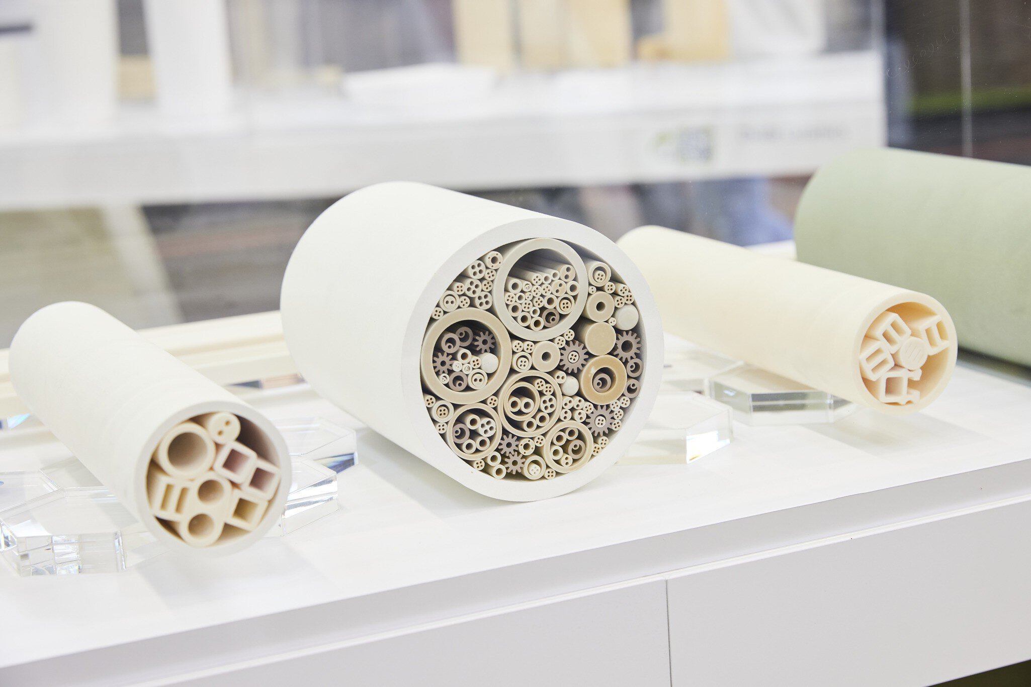 Three cylindrical ceramic filters with intricate inner patterns on a white surface.