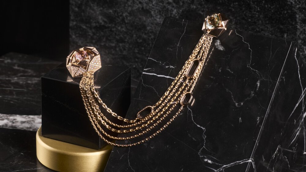 Golden chain bracelet with geometric ends on black marble surfaces.