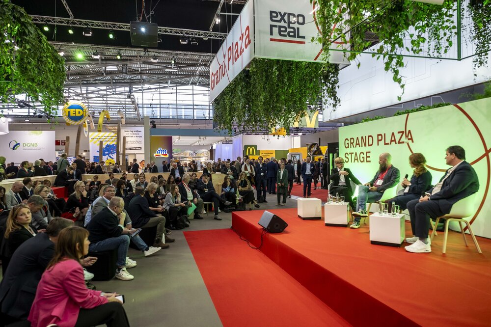 A well-attended panel discussion on the Grand Plaza Stage at EXPO REAL attracts a large audience of trade fair visitors.