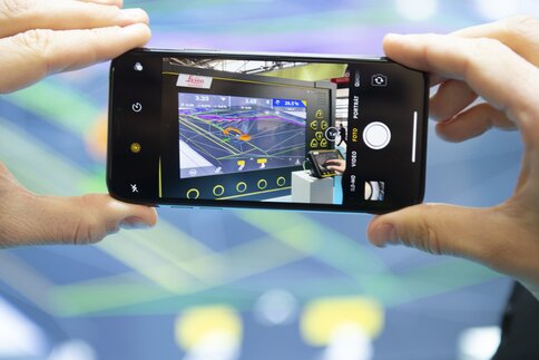 Person takes a picture of a screen full of different diagrams and metrics with a smartphone.