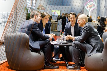 Vier Personen im Gespräch auf einer Messe.