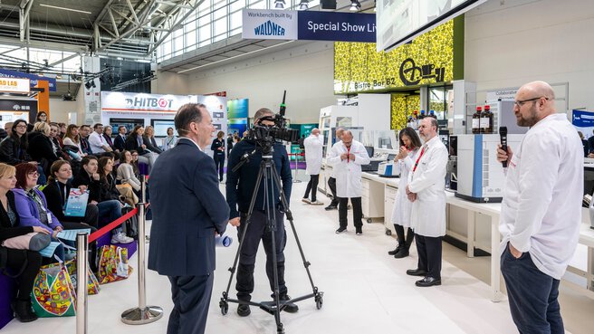 Researchers present their laboratory work to an audience at a trade show