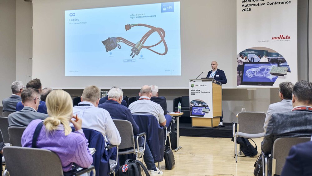 A man presents slides on automotive technology to an audience at the electronica Automotive Conference 2025.