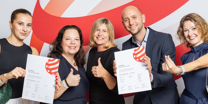 Fünf Menschen lächeln, halten Urkunden in der Hand und zeigen den Daumen nach oben vor einem rot-weißen Hintergrund.