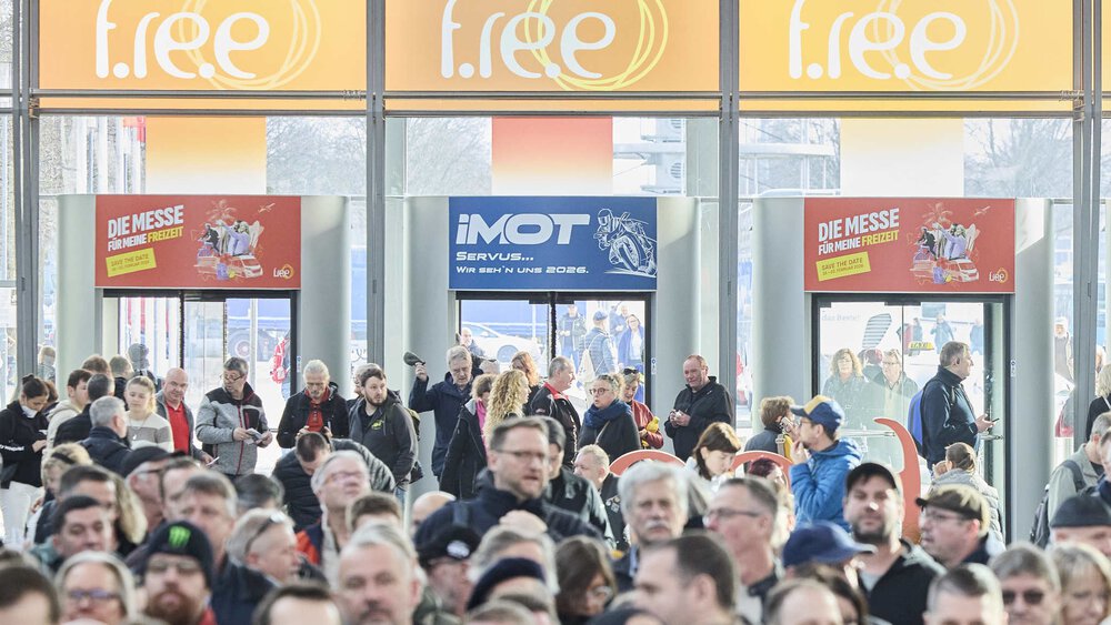 Große Menschenmenge in einer Eingangshalle, über dem Eingang sind Banner für „f.re.e“ und „IMOT“ zu sehen.