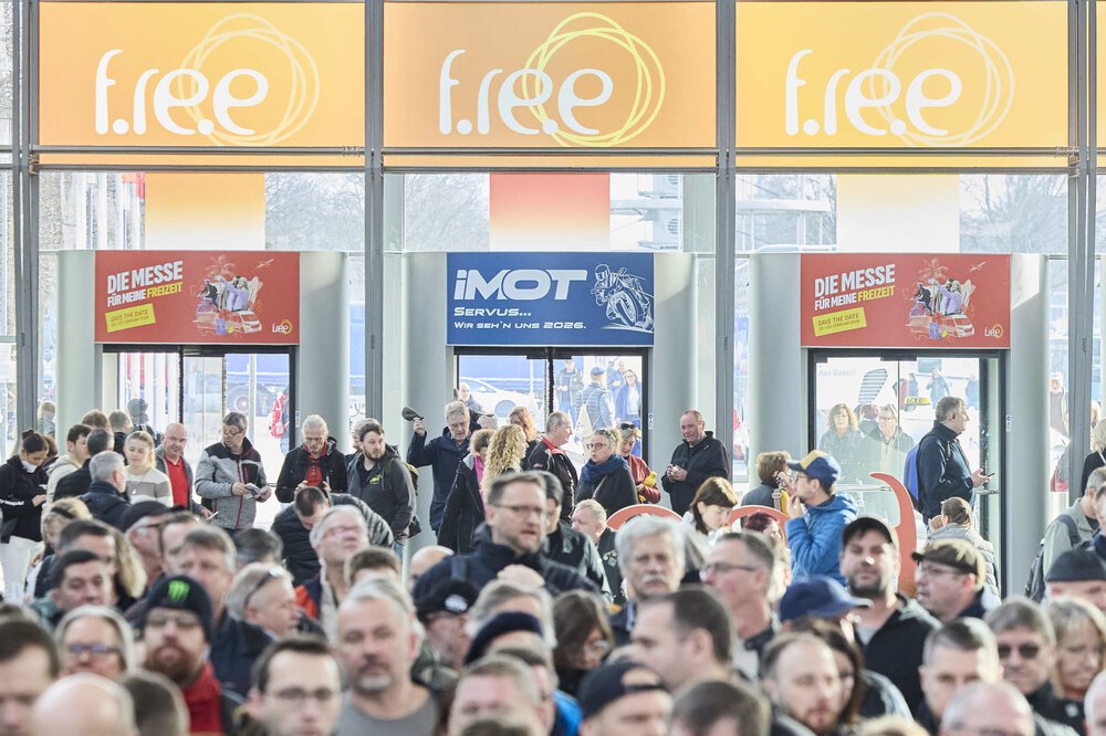Große Menschenmenge in einer Eingangshalle, über dem Eingang sind Banner für „f.re.e“ und „IMOT“ zu sehen.