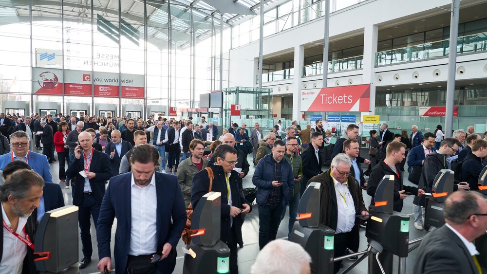 Zahlreiche Messebesucher in einer Eingangshalle der Messe München warten vor den Kontrollscannern auf ihren Einlass zur ceramitec.