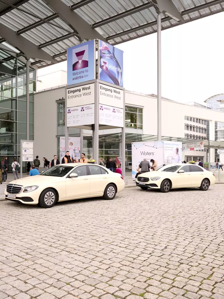 Two cabs parked in front of the entrance to analytica 2024