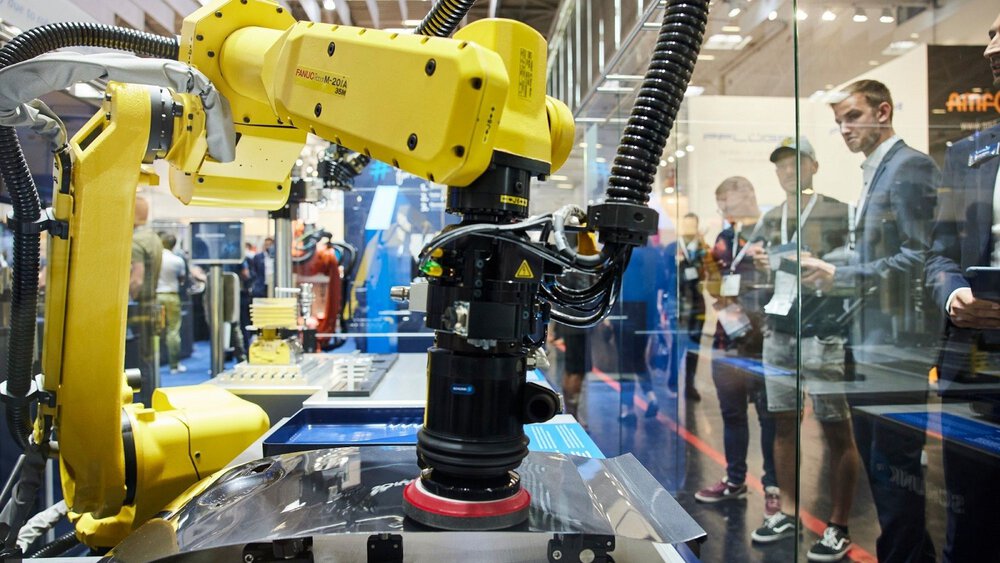 Visitors observe a robot at work during automatica 2022.