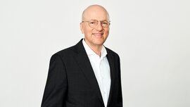 In the photo, you can see Dr. Pfeiffer, CEO of Messe München Group, wearing a suit and smiling.