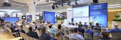 Gruppe von Menschen sitzt in einem Raum und hört einem Vortrag beim Bauma Forum 2022 zu.