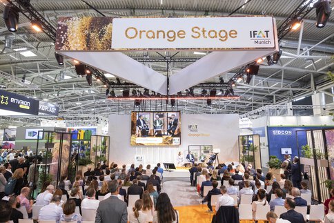 Bühnenveranstaltung auf der Orange Stage auf der Umwelttechnologie-Messe IFAT Munich mit Menschen im Publikum