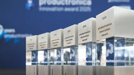 Sechs rechteckige Trophäen aus Glas und Metall zu den unterschiedlichen Kategorien des productronica Innovation Award 2025 stehen nebeneinander aufgereiht.