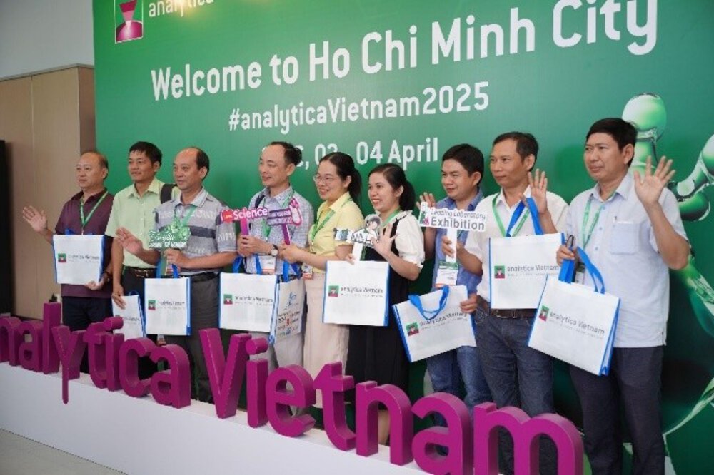 A group of people pose with gift bags at the analytica Vietnam 2025 event in Ho Chi Minh City.