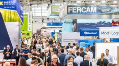 Well-attended exhibition hall during transport logistic with numerous colourful exhibition stands to the right and left.