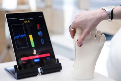 Hand berührt Sensorsystem an einem Modellfuß