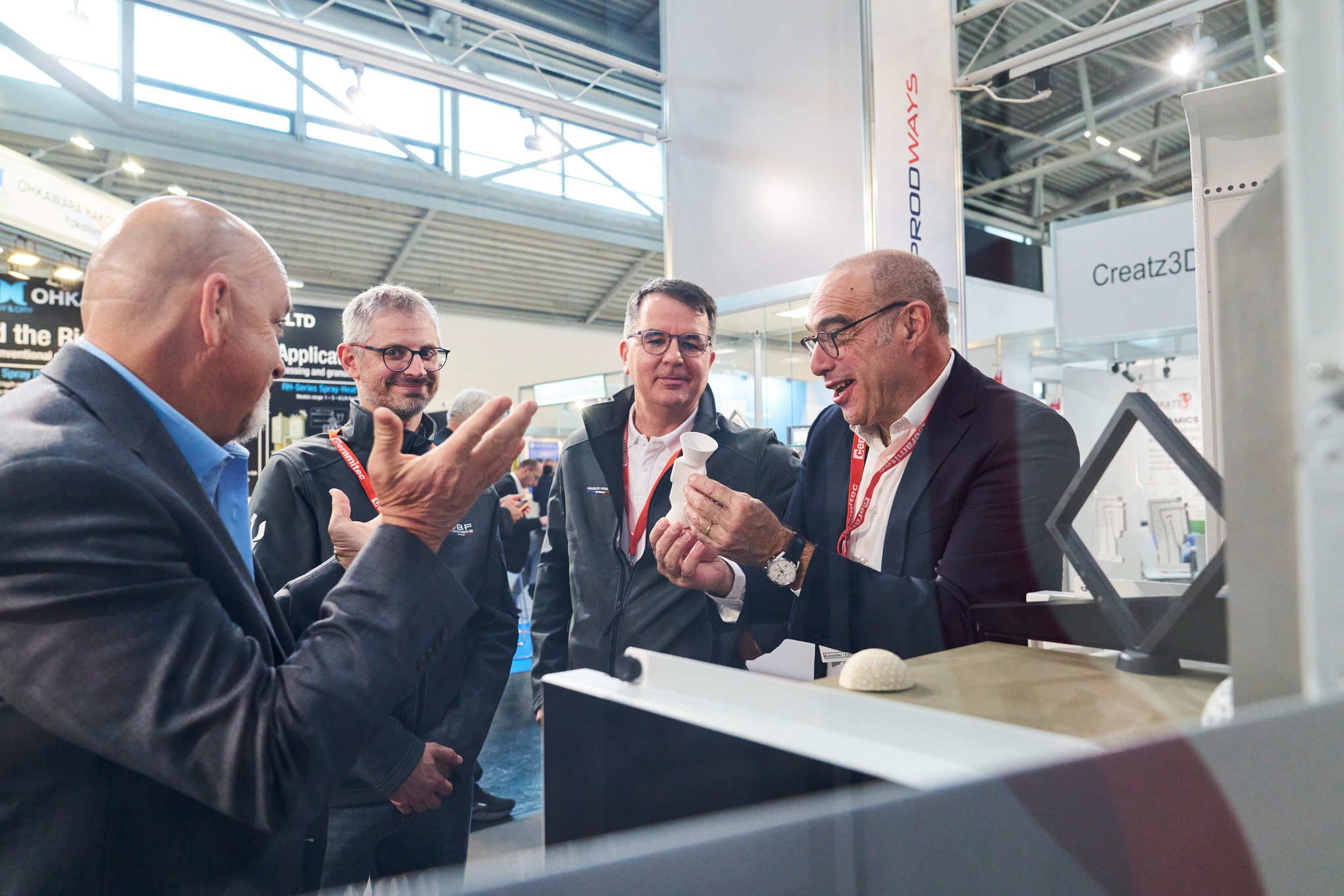 Fachgespräch am Messestand mit Keramikbauteil