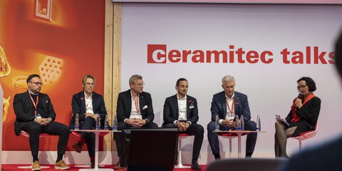 Five-person panel with moderator on stage at the 
