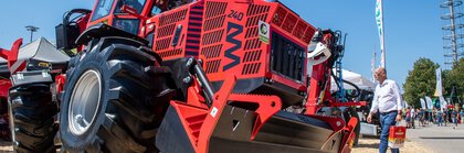  A red special forestry tractor stands jacked up on the open-air site of Messe München during INTERFORST.