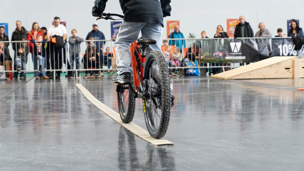 Junge balanciert mit Fahrrad auf einer geraden Linie