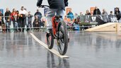 Junge balanciert mit Fahrrad auf einer geraden Linie