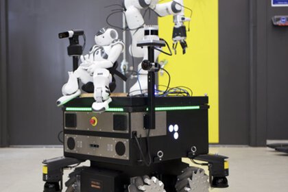 Ein Roboter mit Gelenkarmen und Rädern, konzipiert für vielseitige Aufgaben, vor einer gelben Tür in einem dunkelgrauen Raum.