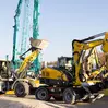 Excavators and loaders in action at a demonstration in the outdoor exhibition area.