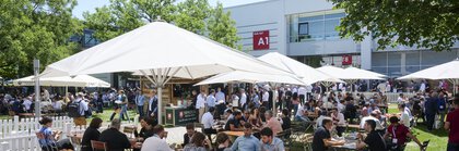 A packed beer garden in the atrium of Messe München