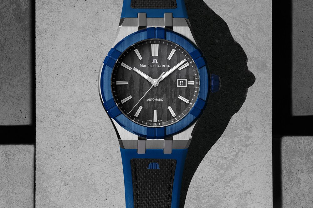 Nahaufnahme einer Armbanduhr von „Maurice Lacroix“ mit einem blau umrandeten Ziffernblatt und einem schwarzen und blauen Armband.