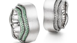 Zwei kunstvolle, nahezu identische gewellte Ringe aus Silber und mit vielen kleinen Diamanten besetzt, der eine mit Grünen und der andere mit Weißen.