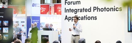 Speaker at the “Integrated Photonics Applications” forum at Laser World of Photonics 2025, audience follows presentation.