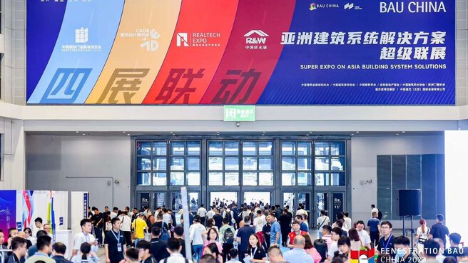 Menschenmenge am Eingang der BAU China Expo unter einem großen bunten Schild mit Text auf Chinesisch und Englisch.