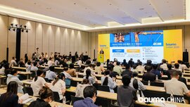 A large conference room in which a large number of people are seated, watching a presentation on bauma CHINA 2026, which is being shown on a large screen at the front of the room.