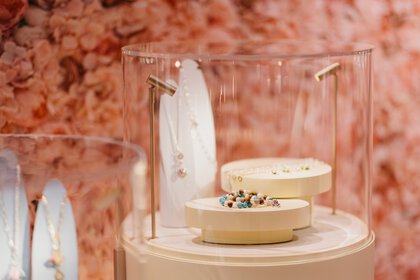 Several pieces of jewelry are displayed in round showcases and illuminated by small lamps.