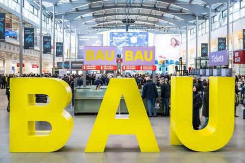 große gelbe BAU Buchstaben Aufsteller in der Eingangshalle der Messe München