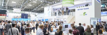 Viele Personen sehen sich einen Messestand an