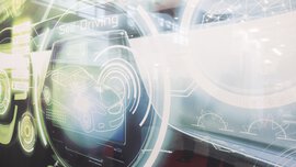 Glowing graphic on autonomous driving shows a stylized car and digital interface elements with the text Self Driving