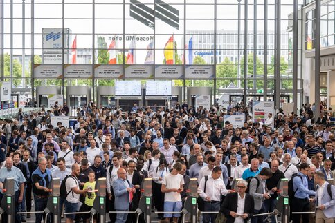 Eine große Menschenmenge versammelt sich vor den Ticketschranken in der Messe Eingangshalle West.