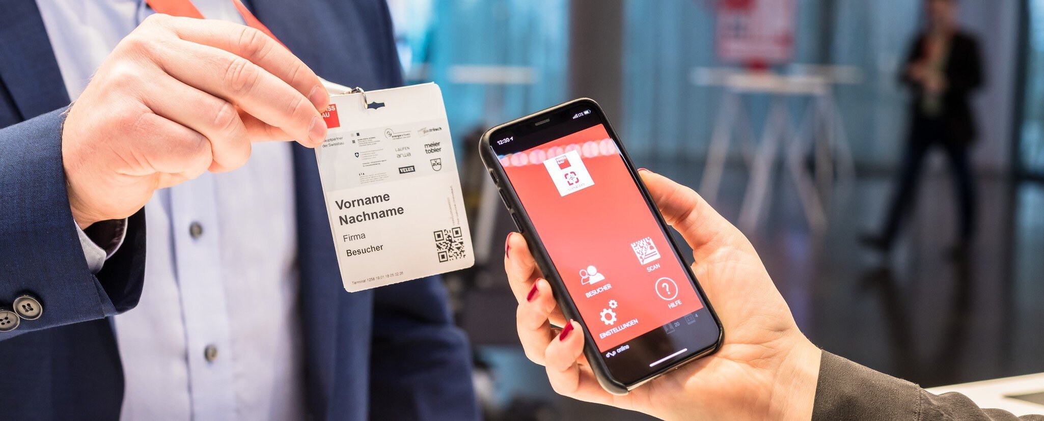 A person with a smartphone scans the QR code of a visitor pass.